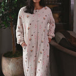 Woman wearing a cream colored long sleeve sleep sack with a book pattern