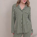 Woman modeling green gingham printed pajamas in a neutral room