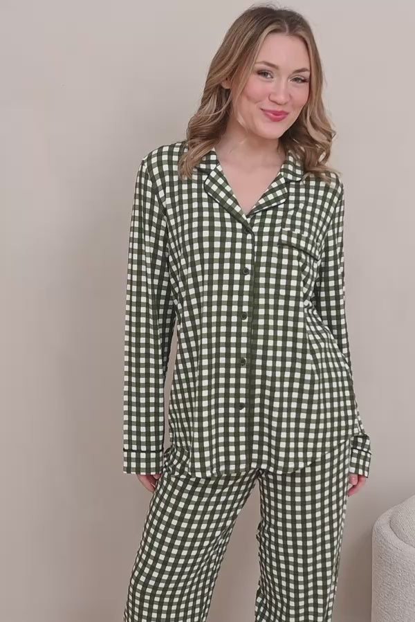 Woman modeling green gingham printed pajamas in a neutral room