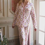 Video of a woman smiling indoors modeling long sleeve pajama set in princess
::: Model is 5'9" wearing size XS ///