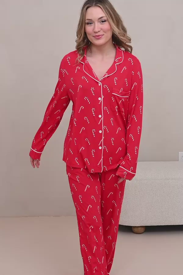 Video of a woman modeling candy cane printed red pajamas in a neutral room