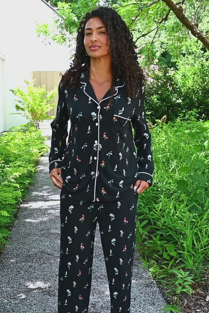 Woman modeling long sleeve black pajama set with wildflower pattern in outdoor setting ::: Model is 5'10" wearing size S ///