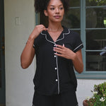 Video of woman modeling a short sleeve black pajama set with white piping ::: Model is 5'9"" wearing size S ///