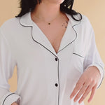 Woman modeling white pajama with black piping ::: Model is 5'6" wearing size M ///