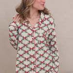 Woman modeling holiday bow and greenery printed pajamas 