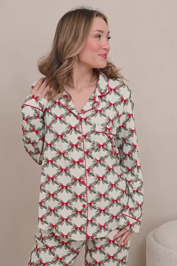 Woman modeling holiday bow and greenery printed pajamas 