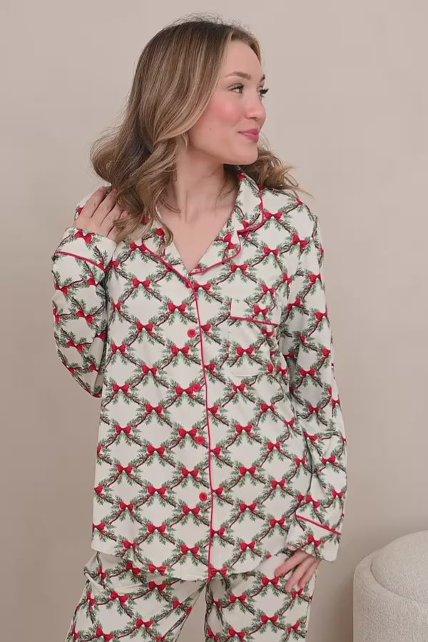 Woman modeling holiday bow and greenery printed pajamas 