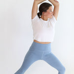 Model stretching wearing the Bamboo Flex Women’s Leggings in Slate standing in front of a white backdrop