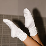 White socks being worn on a tiled floor