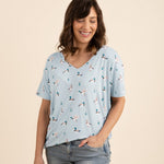 Woman wearing a light blue duck printed v-neck and jeans on a beige background  ::: Model is 5'5" wearing size S ///
