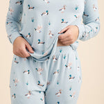 Light blue pajama set with duck pattern worn by a person on a beige background