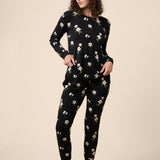 Woman wearing a black floral pajama set on a beige background ::: Model is 5'11" wearing size M ///
