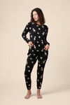 Woman wearing a black floral pajama set on a beige background ::: Model is 5'11" wearing size M ///
