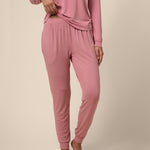 Person wearing a pink pajama set on a beige background