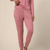 Person wearing a pink pajama set on a beige background