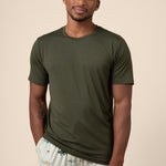 Man wearing dark green Men's Short Sleeve Tee & Pant PJ Set with pocket in Fishing print on a beige background