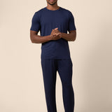 Man wearing Men's Short Sleeve & Pant PJ Set in Navy on beige background