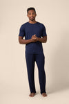 Man wearing Men's Short Sleeve & Pant PJ Set in Navy on beige background