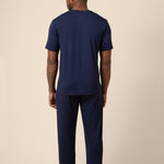 Man showing back side of Men's Short Sleeve & Pant PJ Set in Navy on beige background