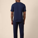 Man showing back side of Men's Short Sleeve & Pant PJ Set in Navy on beige background