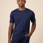 Man posing in Men's Short Sleeve & Pant PJ Set with pocket in Navy on beige background