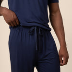 Man showcasing the Men's PJ Pant  with drawstring in Navy over a Men's Navy short sleeve tee on beige background
