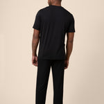 Man showing back side of Black Men's Short Sleeve & Pant PJ Set on beige background