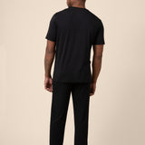 Man showing back side of Black Men's Short Sleeve & Pant PJ Set on beige background