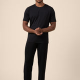 Man wearing Black Men's Short Sleeve & Pant PJ Set on beige background