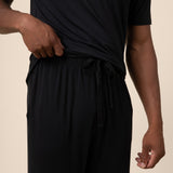 Man showcasing Black PJ pant  with drawstring over Men's short sleeve tee in midnight on beige background