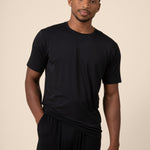 Man posing in Men's Short Sleeve & Pant PJ Set with pocket in midnight on beige background