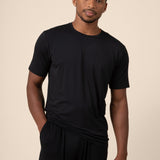 Man posing in Men's Short Sleeve & Pant PJ Set with pocket in midnight on beige background